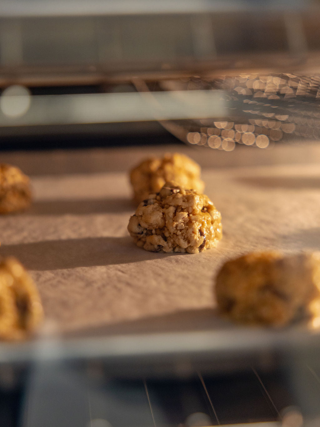 Baked cookies on a baking sheet with an oven in the background