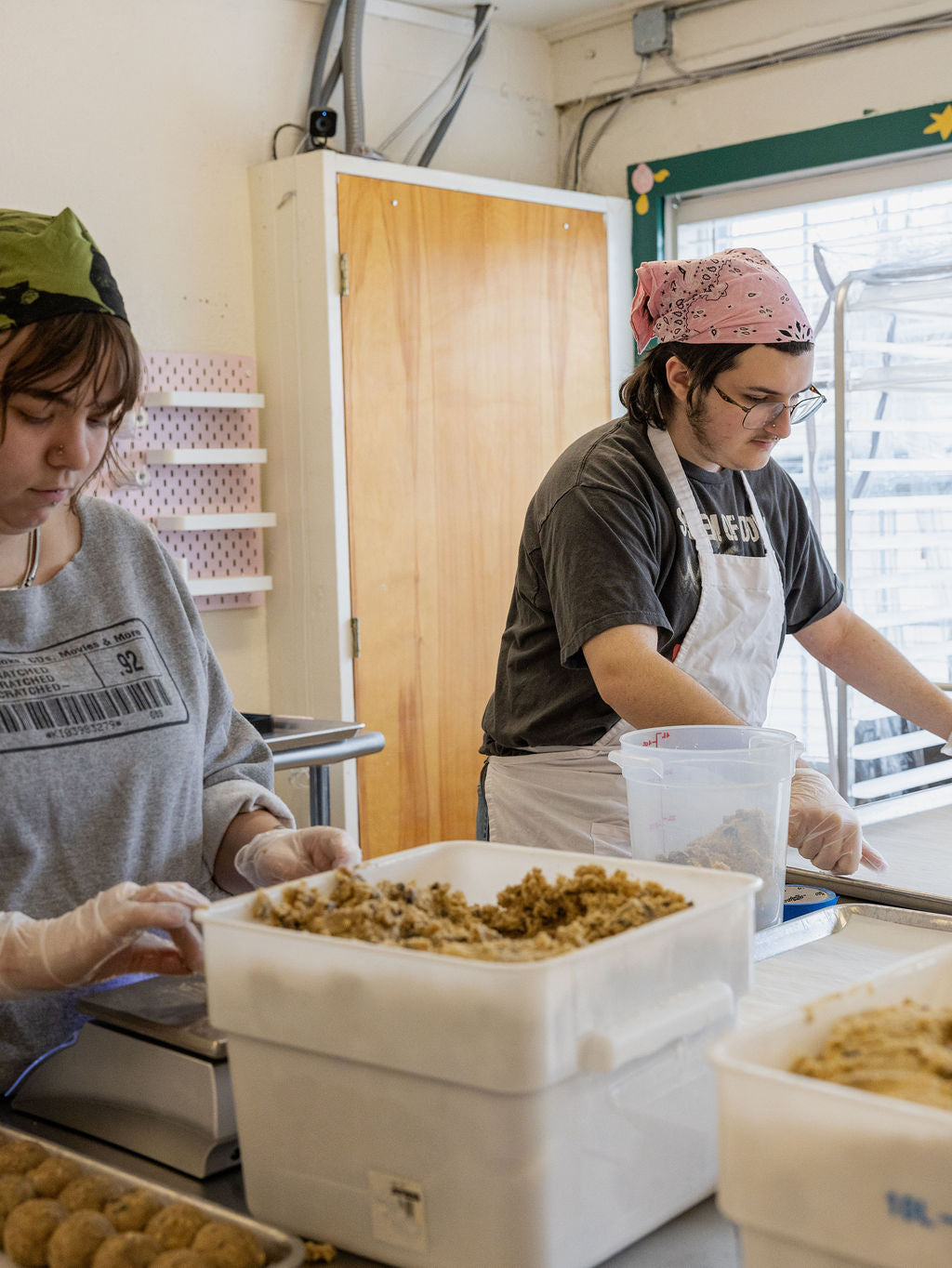 Two people working in a kitchen, preparing food.