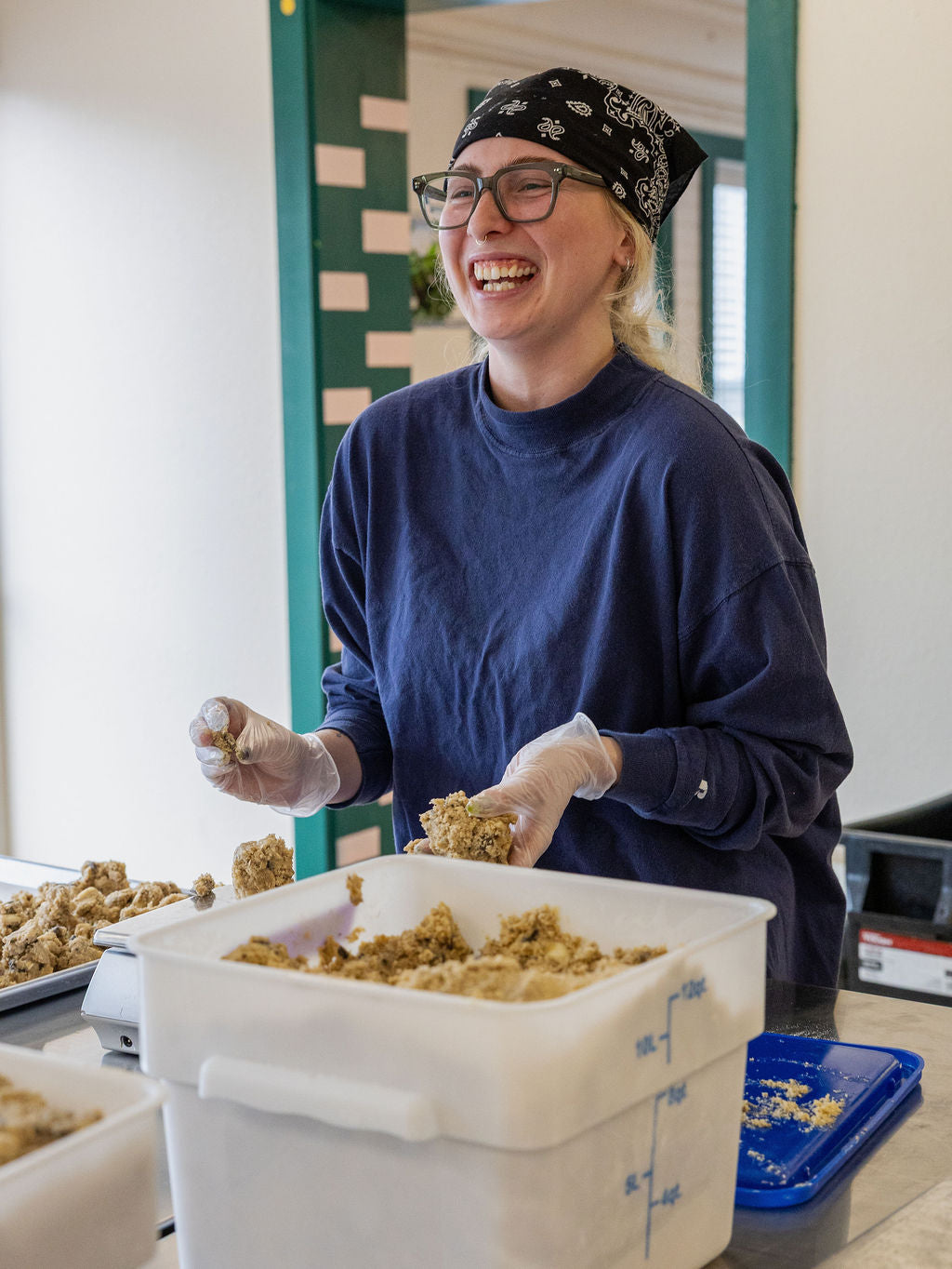 Person in a kitchen setting, preparing food with a container of ingredients.