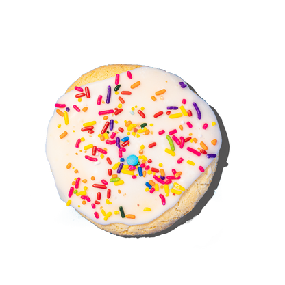 Cookie with white icing and colorful sprinkles on a white background