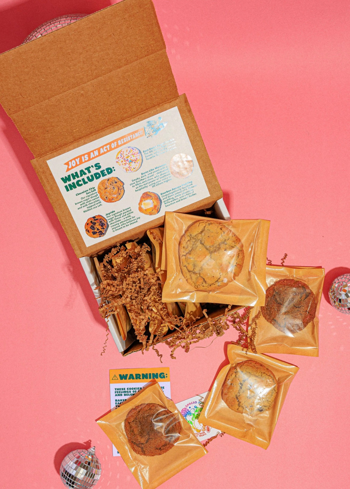 Open box containing various items on a pink background