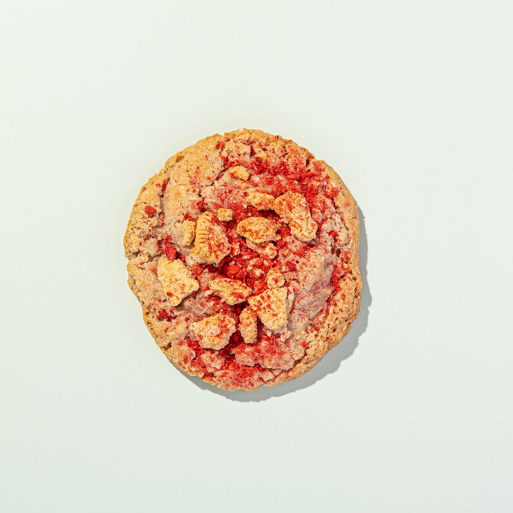 Cookie with visible strawberry pieces on a light background