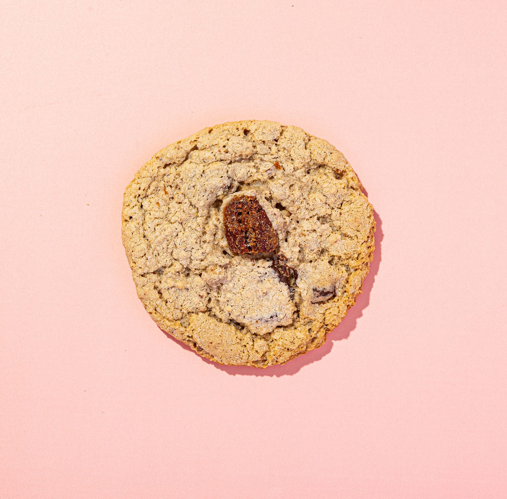Cookie with visible chocolate on a pink background