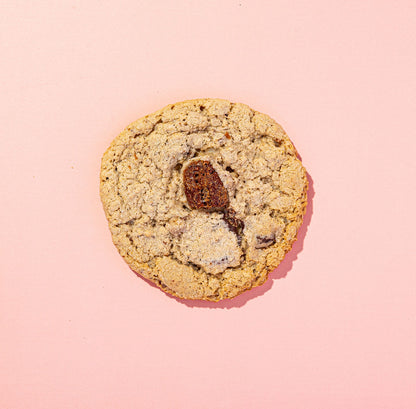 Cookie with visible chocolate on a pink background