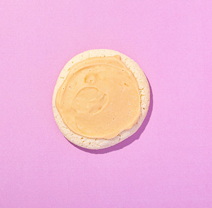 Round cookie with a yellow icing on a pink background